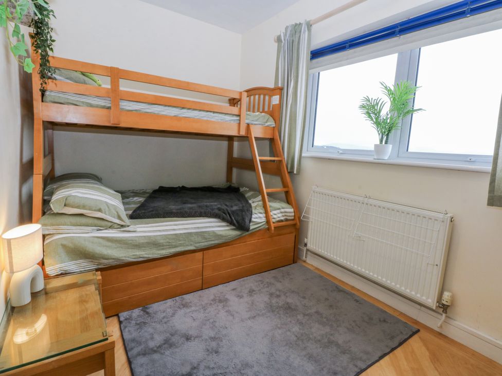 A bedroom with a bunk bed and a window at Snowdonia View in Pwllheli