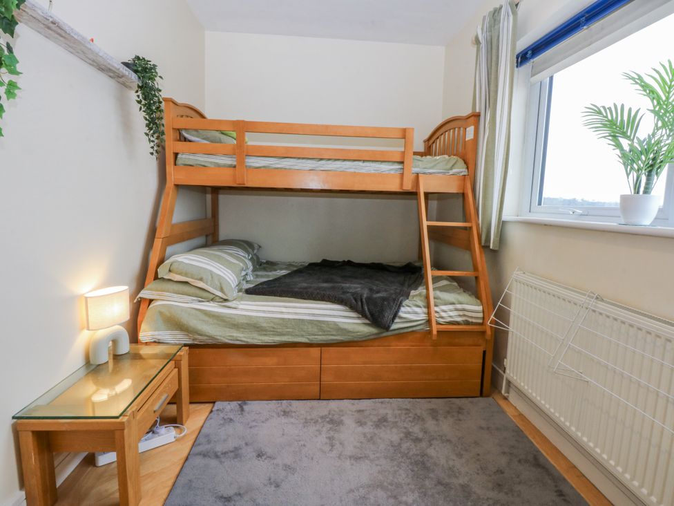 A bedroom with a bunk bed and nightstand at Snowdonia View in Pwllheli