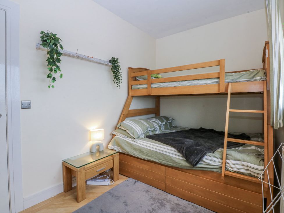 A bedroom with a bunk bed and lamp at Snowdonia View in Pwllheli