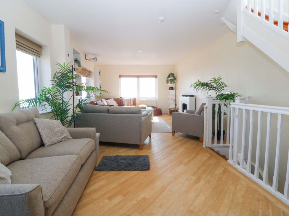 A living room with couches and plants at Snowdonia View in Pwllheli