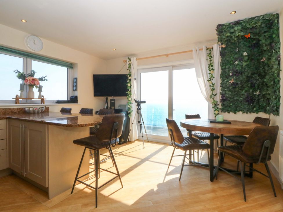 A kitchen with a dining table and chairs at Snowdonia View in Pwllheli