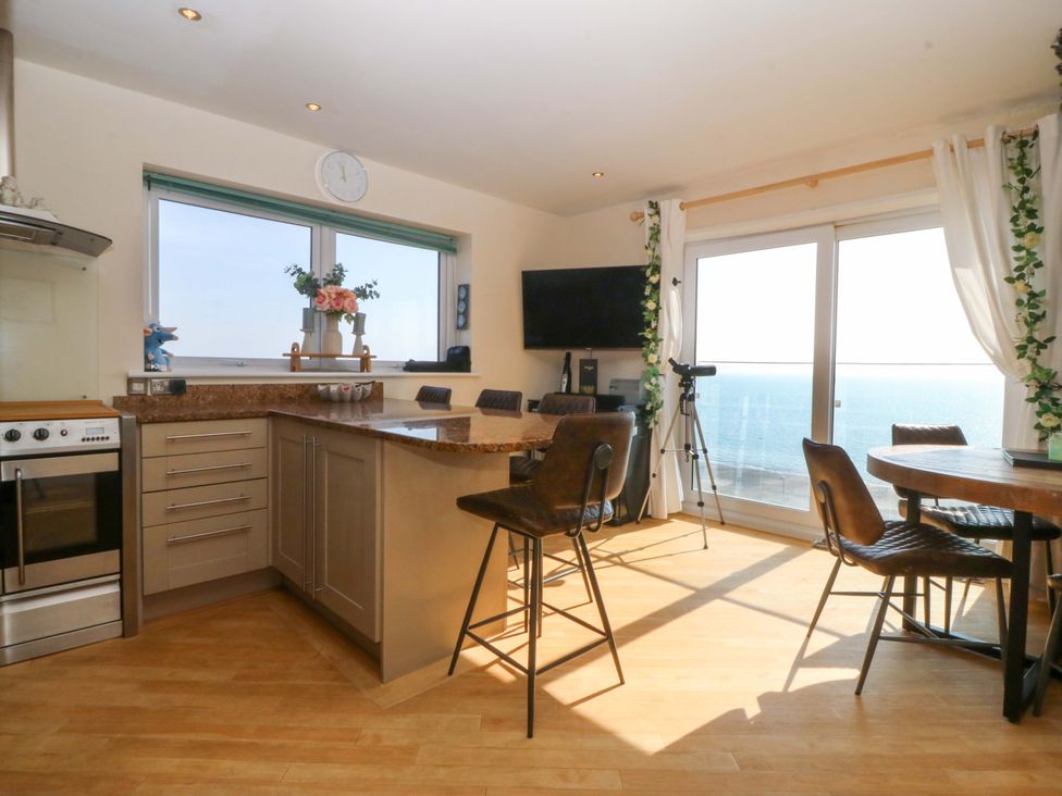 A kitchen with windows and ocean view at Snowdonia View in Pwllheli