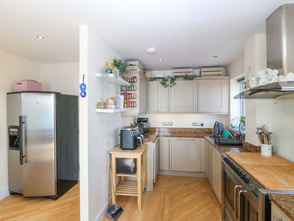 A kitchen with cabinets and a refrigerator at Snowdonia View in Pwllheli