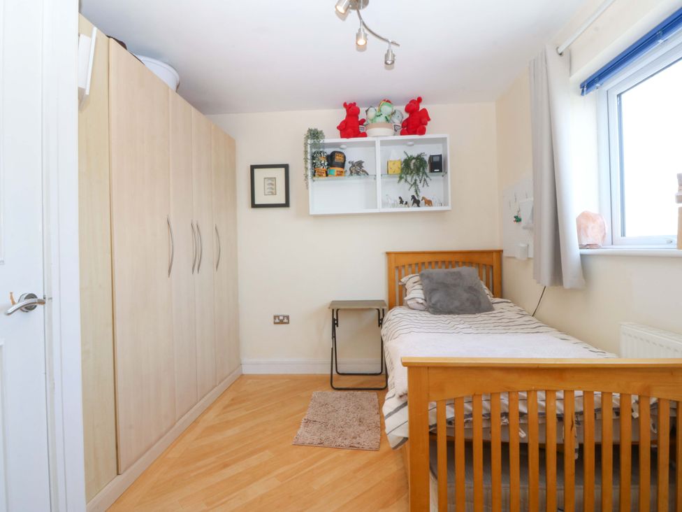 A bedroom with a bed and wardrobe at Snowdonia View in Pwllheli
