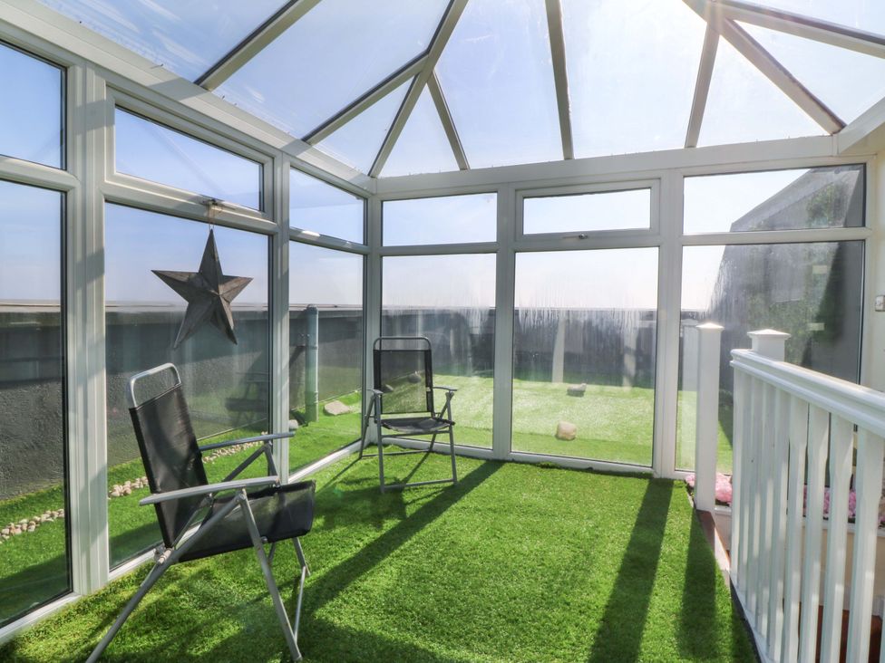 A conservatory with chairs and a star decoration at Snowdonia View in Pwllheli