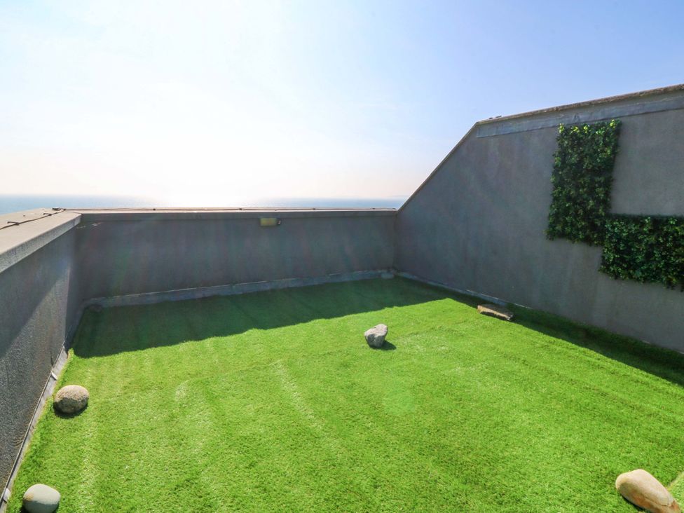 An outdoor space with artificial grass and rocks at Snowdonia View in Pwllheli