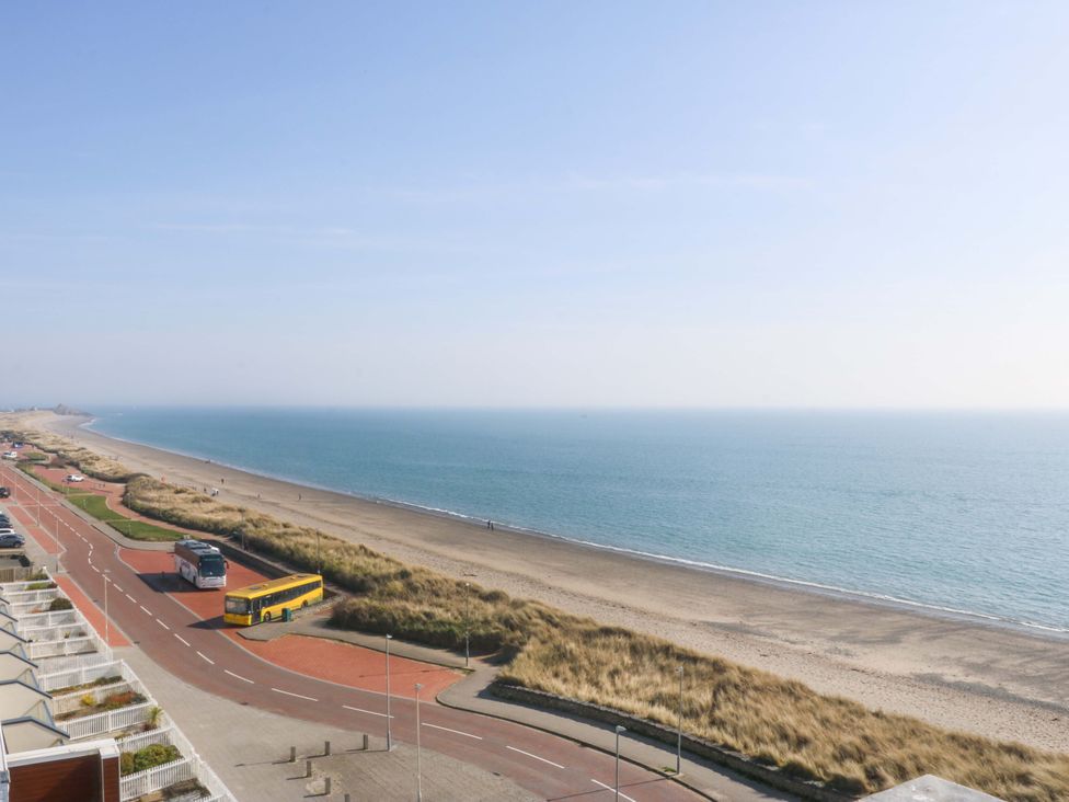A beach with a road and bus at Snowdonia View in Pwllheli