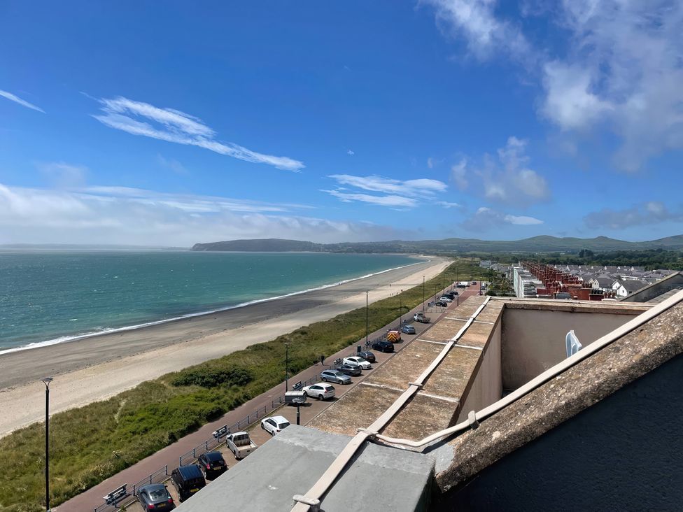A view of the beach and ocean from a rooftop at Snowdonia View in Pwllheli