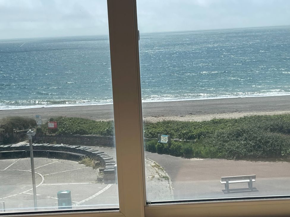 A view of the beach and sea from a window at Snowdonia View in Pwllheli