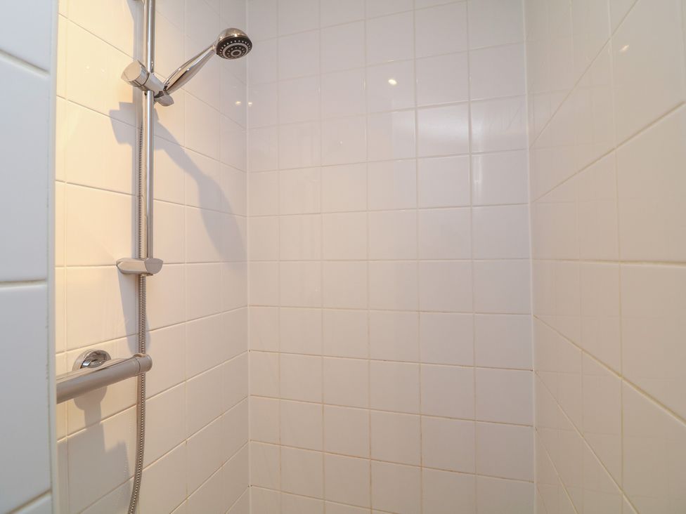 A shower with white tiles and a showerhead at Fairways 22 in Lincoln
