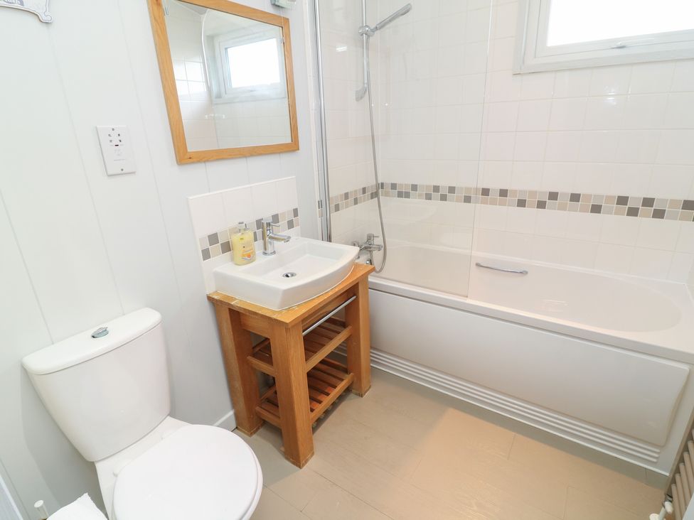 A bathroom with a toilet, sink, bathtub, and shower at Fairways 22 in Lincoln