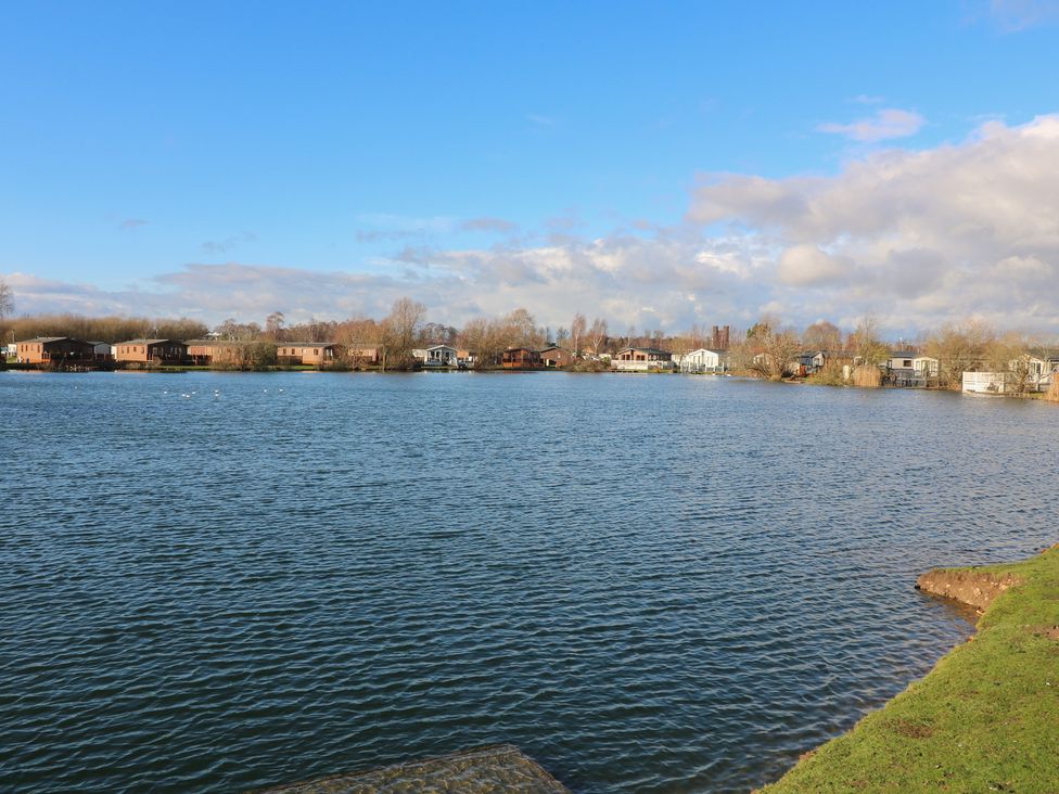 A view of a lake with houses and trees at Fairways 22, Lincoln