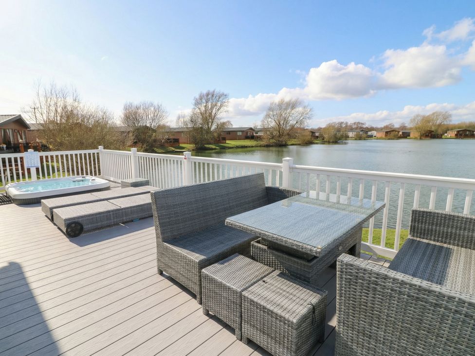 A deck with outdoor furniture and a hot tub at Fairways 22 in Tattershall