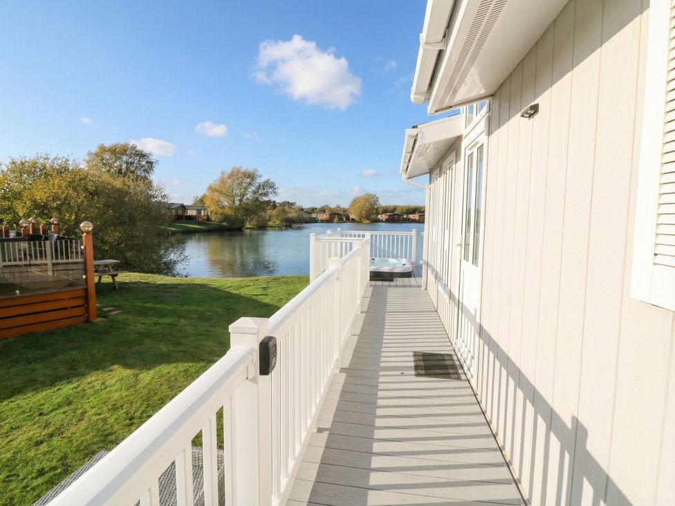 An outdoor balcony with a view of water and trees at Fairways 22 in Tattershall