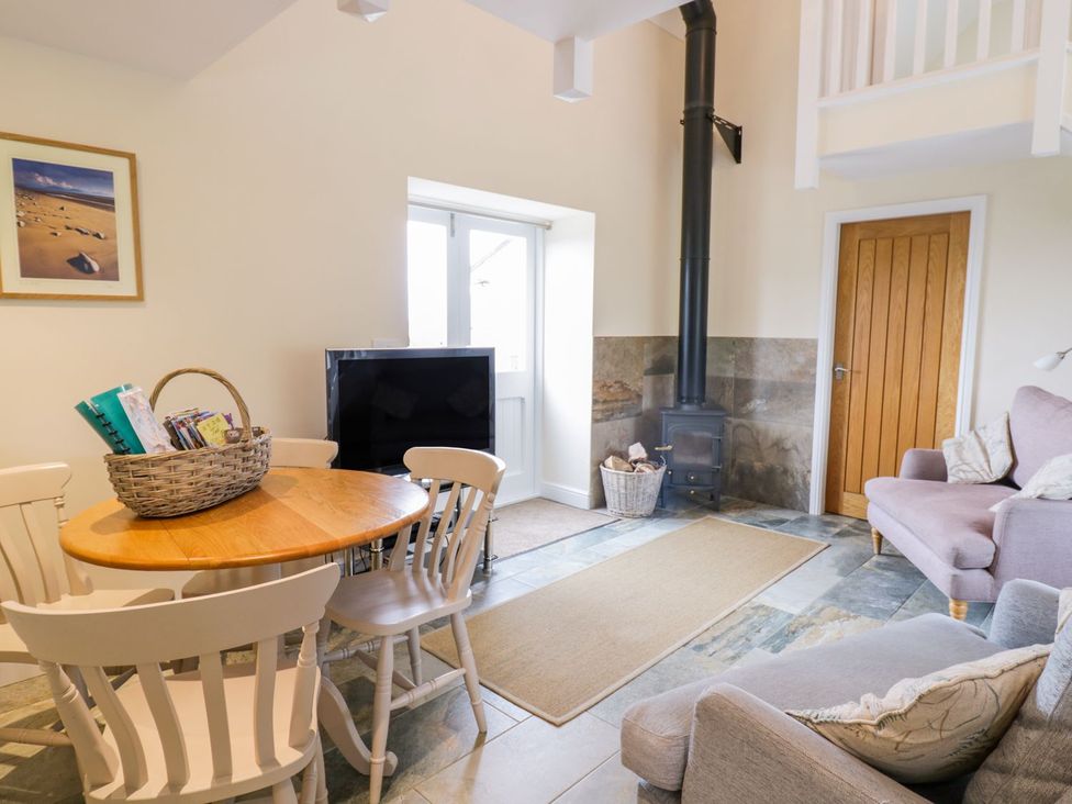 A living room with a dining table and chairs at Plas Tirion Cottage in Holywell