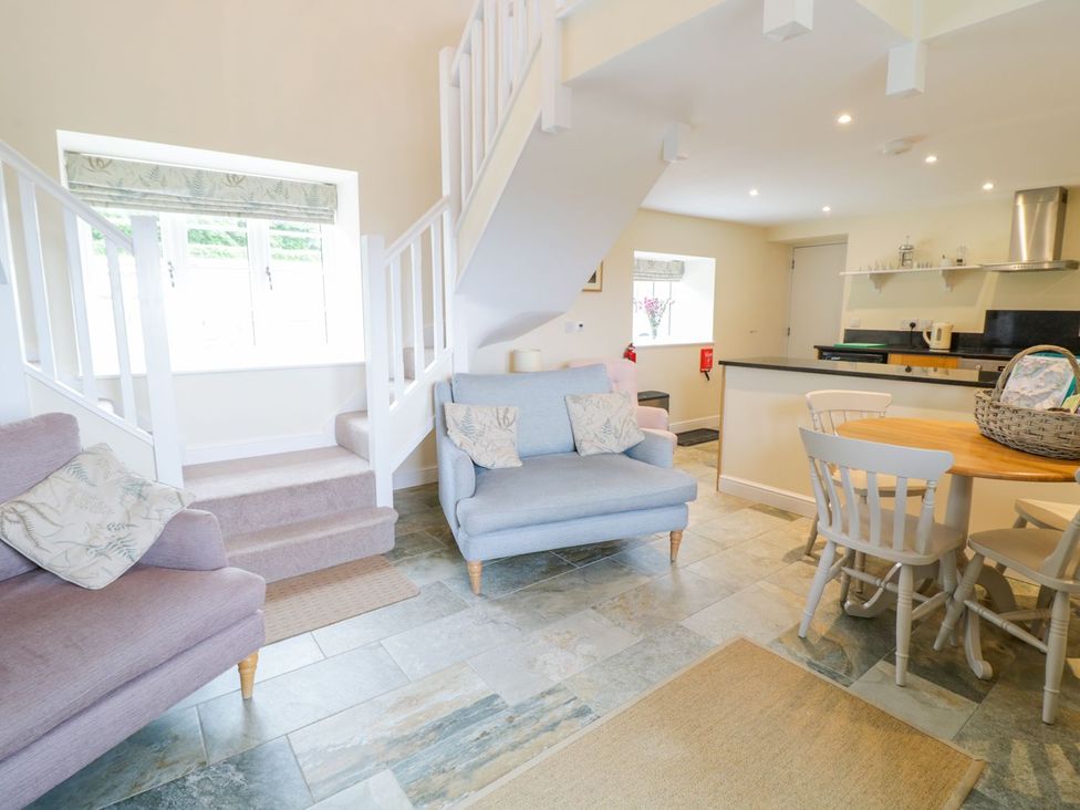 A living room with a sofa and dining table at Plas Tirion Cottage in Holywell