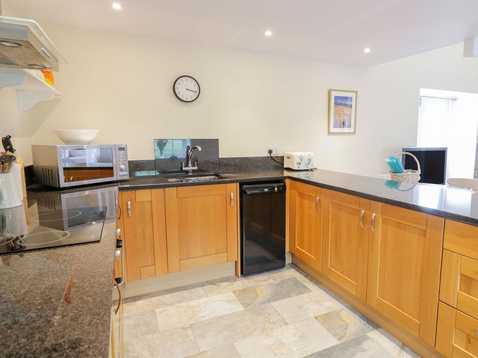 A kitchen with cabinets and appliances at Plas Tirion Cottage in Holywell