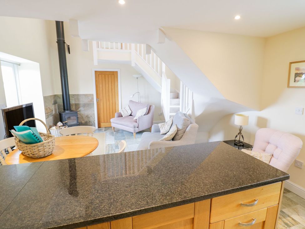 A living room with a dining table and sofa at Plas Tirion Cottage in Holywell