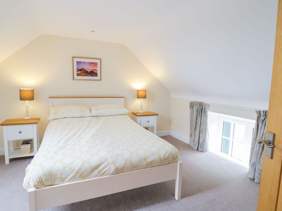 A bedroom with a bed and nightstands at Plas Tirion Cottage Holywell