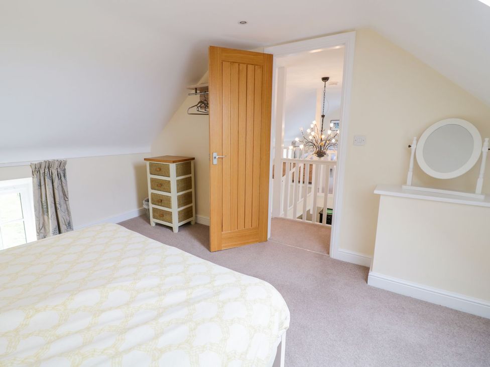 A bedroom with a bed and a drawer unit at Plas Tirion Cottage Holywell