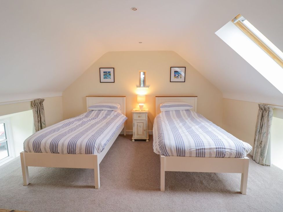 A bedroom with two single beds and a lamp at Plas Tirion Cottage in Holywell