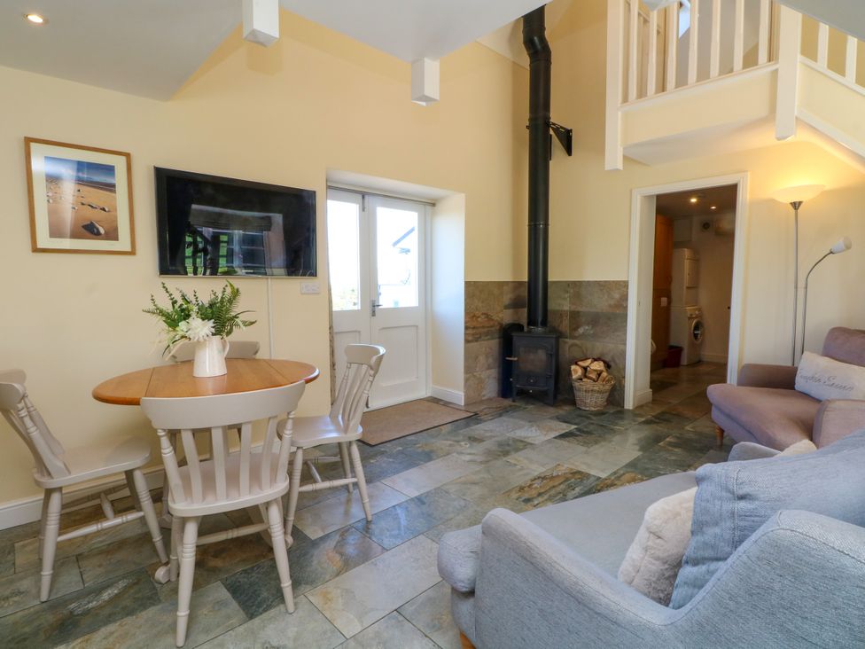 A living room with a table and chairs near a door at Plas Tirion Cottage Mostyn near Holywell