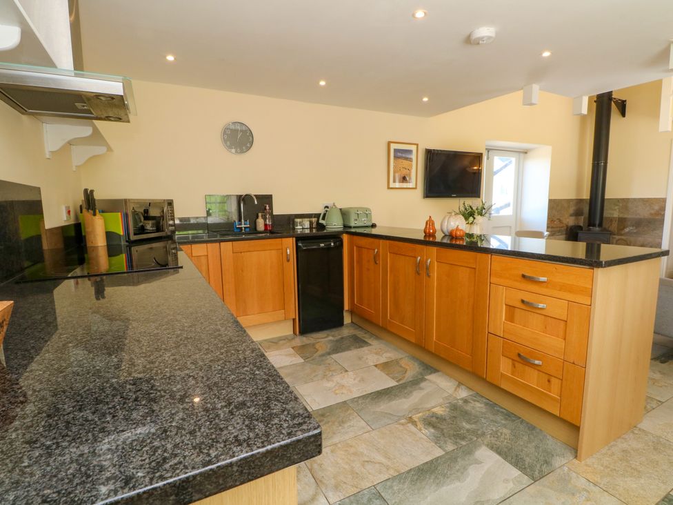 A kitchen with appliances and cabinetry at Plas Tirion Cottage Mostyn near Holywell