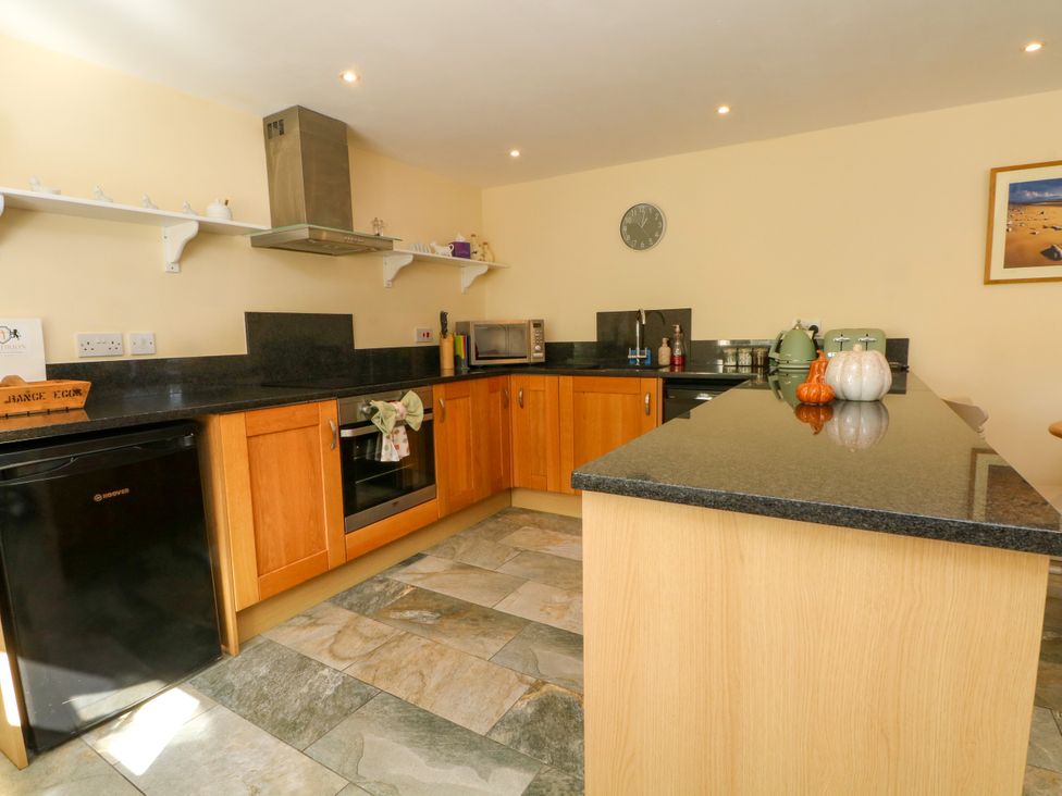 A kitchen with appliances and countertops at Plas Tirion Cottage Mostyn near Holywell