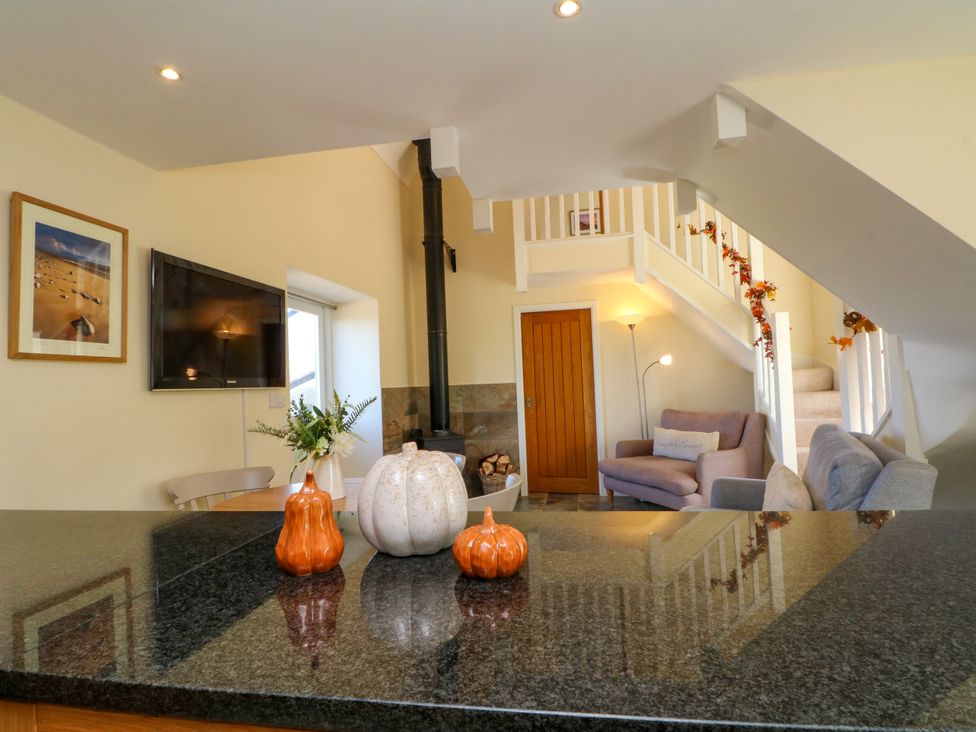 A living room with a television and sofa at Plas Tirion Cottage in Mostyn near Holywell