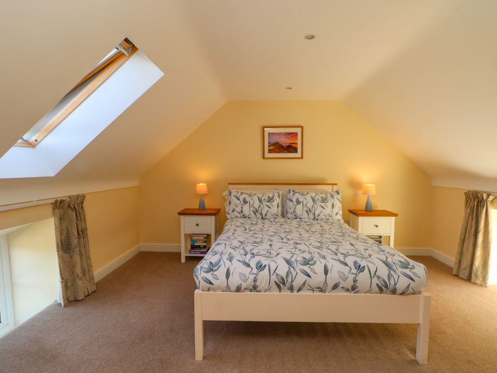 A bedroom with a bed and nightstands at Plas Tirion Cottage Mostyn near Holywell