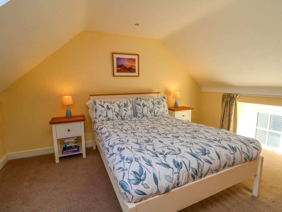 A bedroom with a bed and two nightstands at Plas Tirion Cottage Mostyn near Holywell