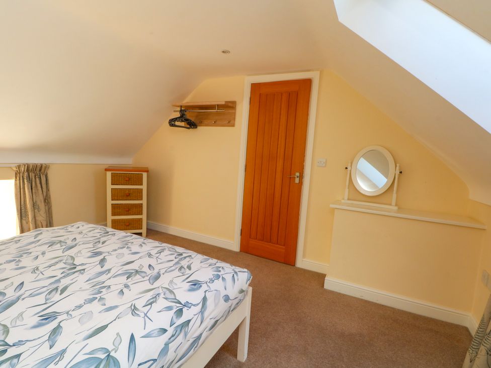 A bedroom with a bed and a drawer unit at Plas Tirion Cottage Mostyn near Holywell
