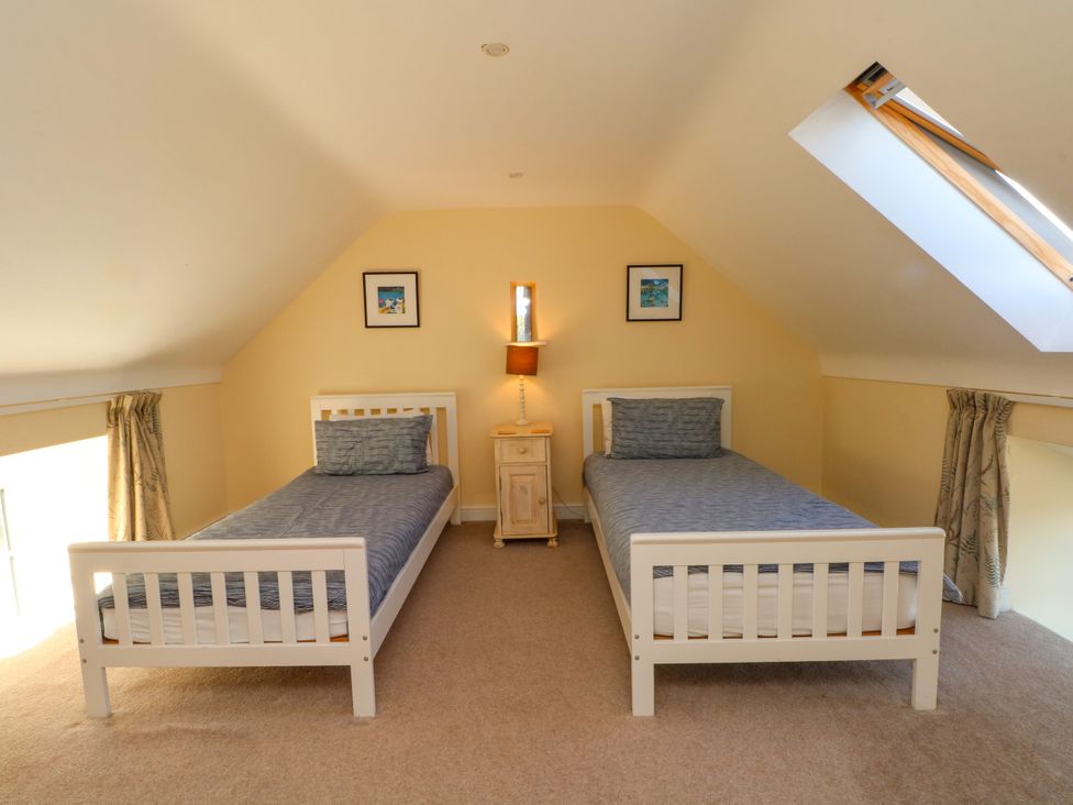 A bedroom with two beds and a nightstand at Plas Tirion Cottage Mostyn near Holywell
