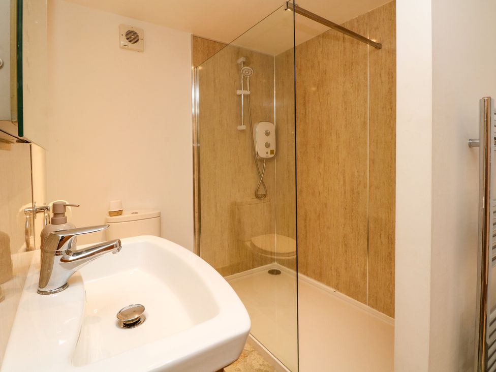 A bathroom with a sink and a shower at Plas Tirion Cottage Mostyn near Holywell