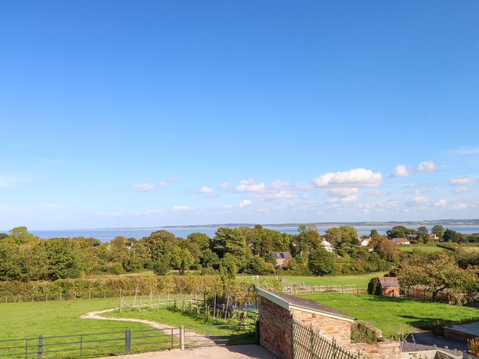 A landscape view with trees and water at Plas Tirion Cottage in Mostyn near Holywell