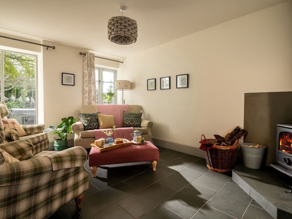 A living room with an armchair and sofa at Shepherds Cottage in Llandrillo
