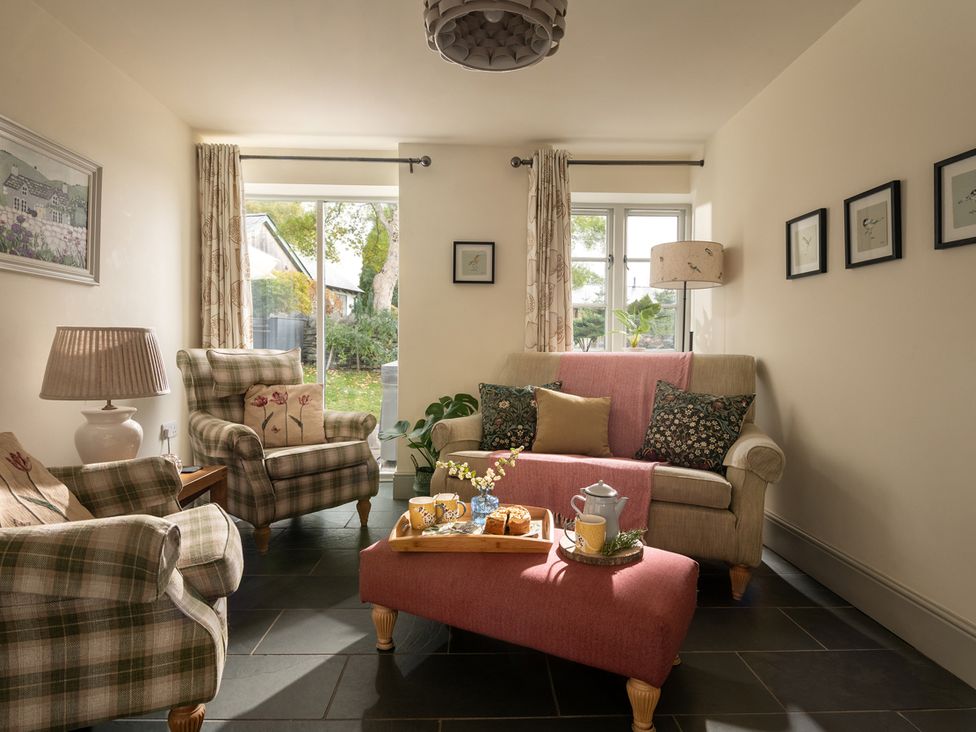 A living room with a sofa and armchairs at Shepherds Cottage in Llandrillo
