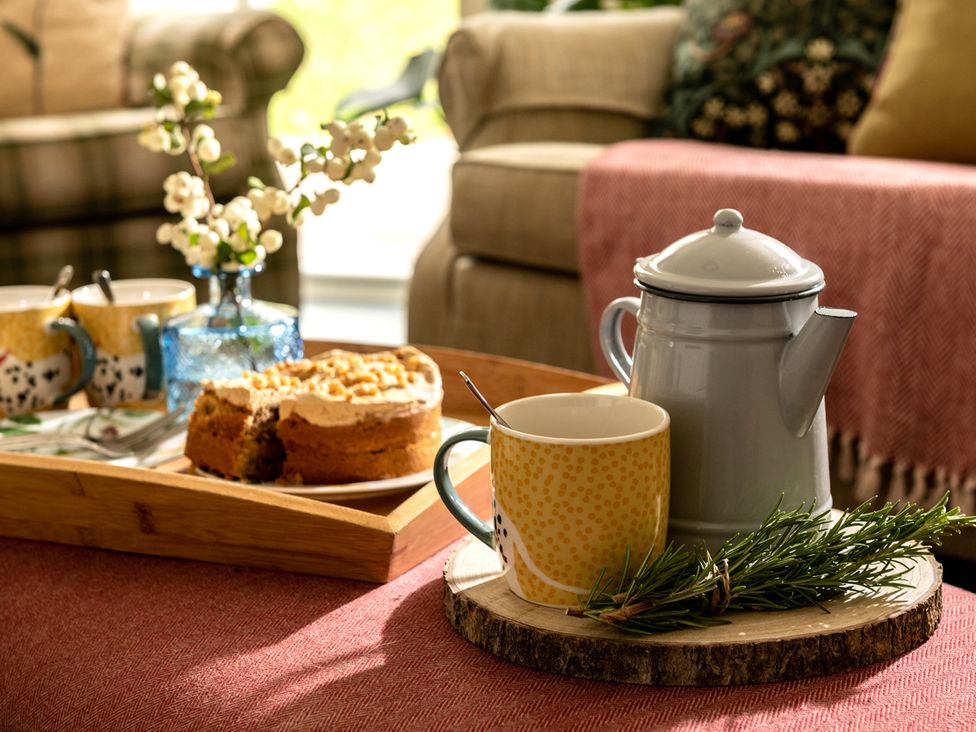 A living room setup with tea and cake at Shepherds Cottage in Llandrillo