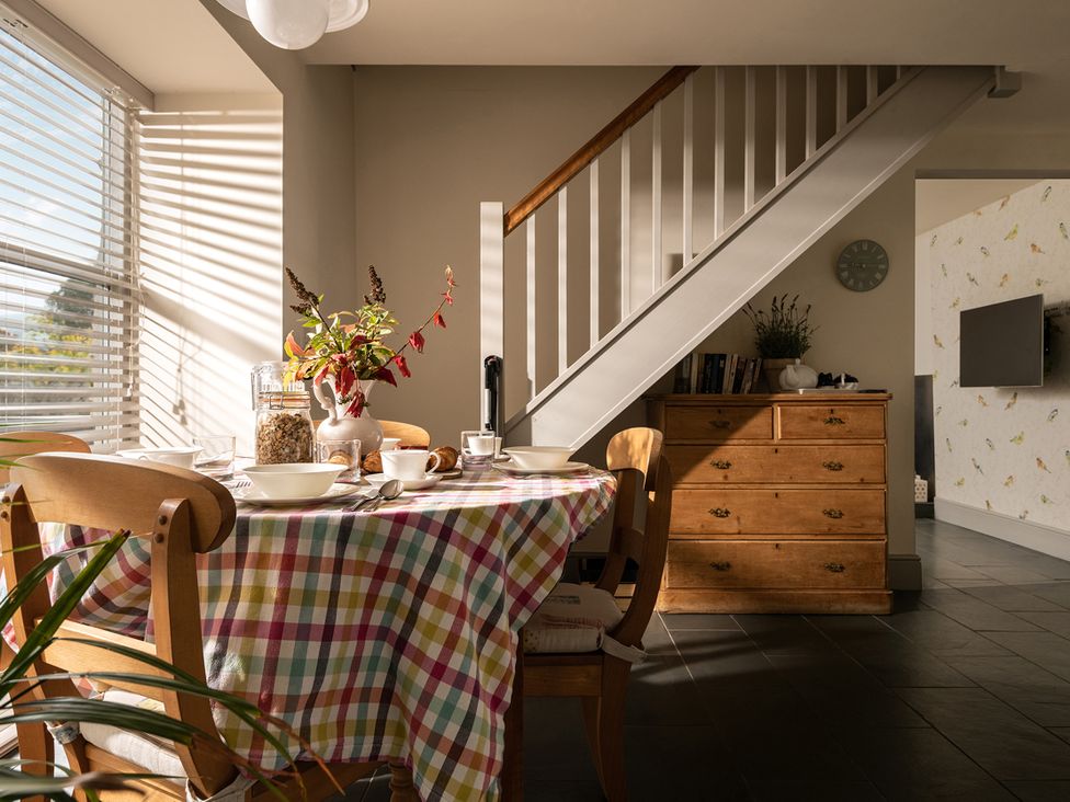 A dining room with a table and chairs at Shepherds Cottage in Llandrillo