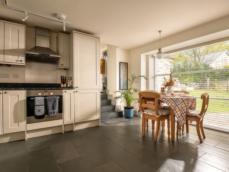 A kitchen with a dining table and chairs at Shepherds Cottage in Llandrillo