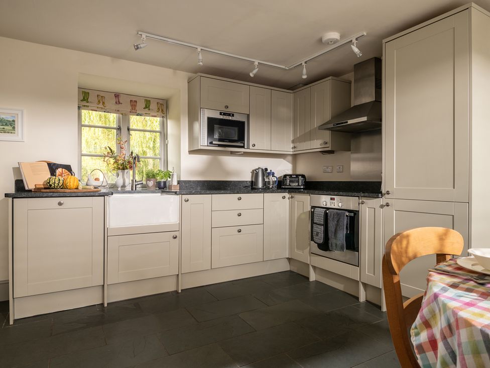 A kitchen with cabinets and a sink at Shepherds Cottage in Llandrillo