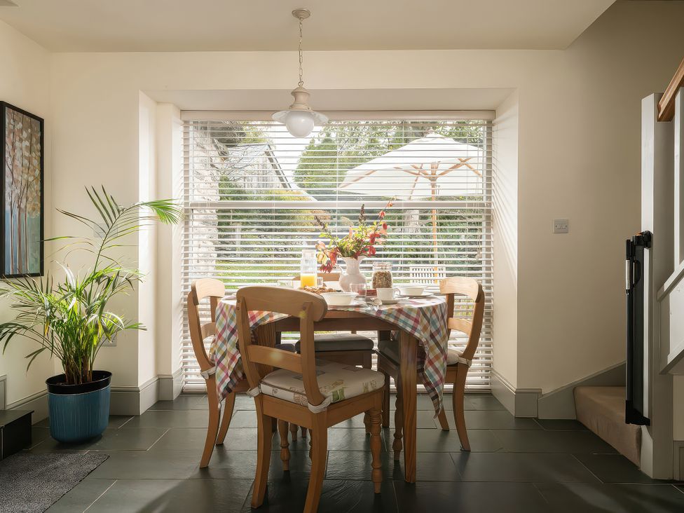A dining room with a table and chairs at Shepherds Cottage in Llandrillo