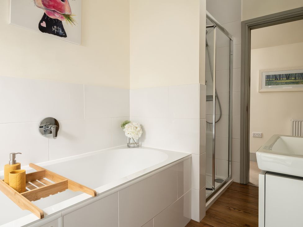 A bathroom with a shower and bathtub at Shepherds Cottage Llandrillo