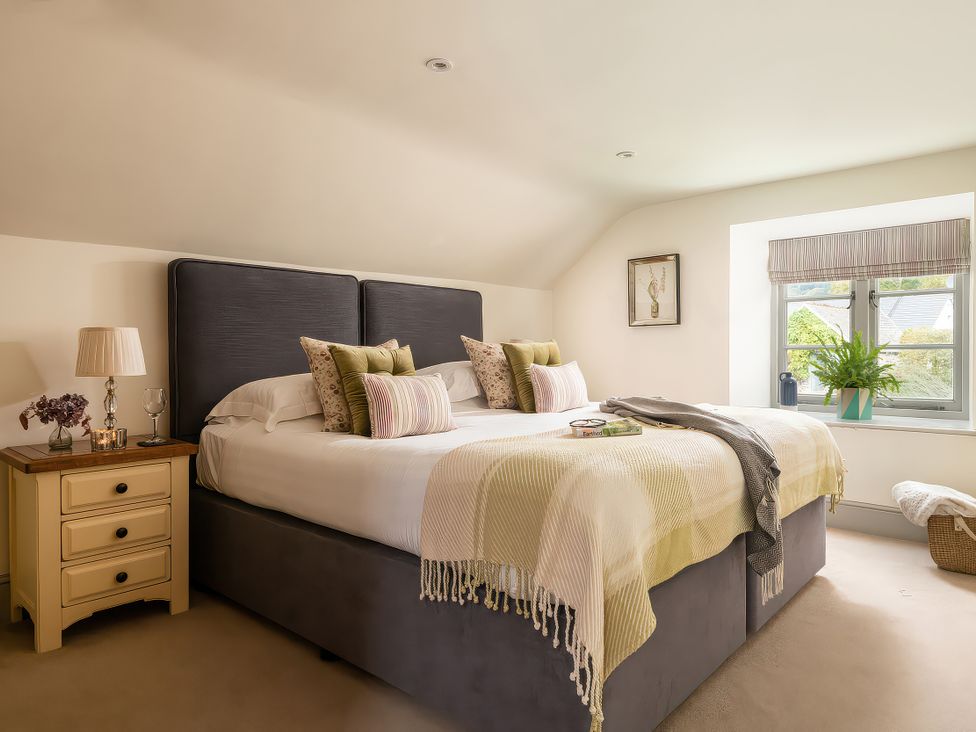 A bedroom with a bed and bedside table at Shepherds Cottage in Llandrillo