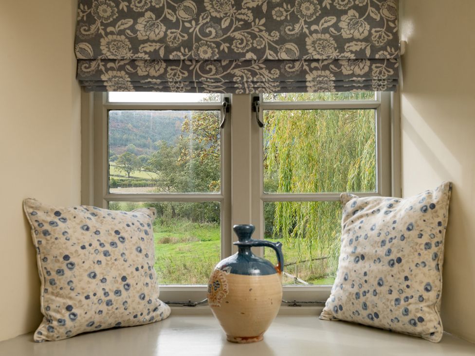 A snug with pillows and a decorative vase at Shepherds Cottage in Llandrillo