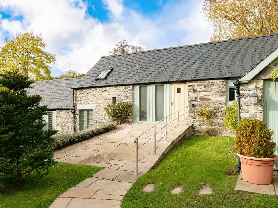 A house with a stone exterior and pathway at Flyfishers Cottage in Llandrillo