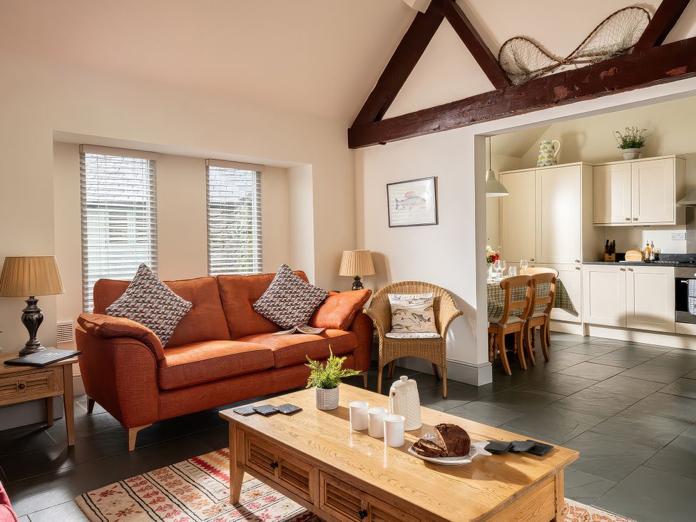 A living room with a sofa and coffee table at Flyfishers Cottage in Llandrillo