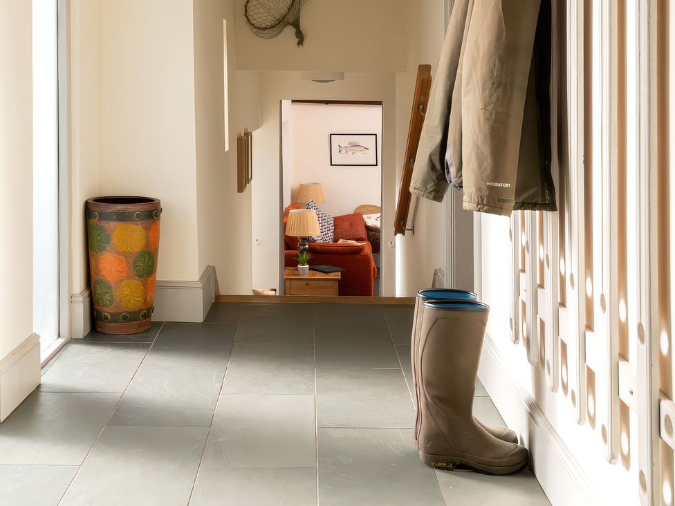 A hallway with a coat and wellies at Flyfishers Cottage Llandrillo