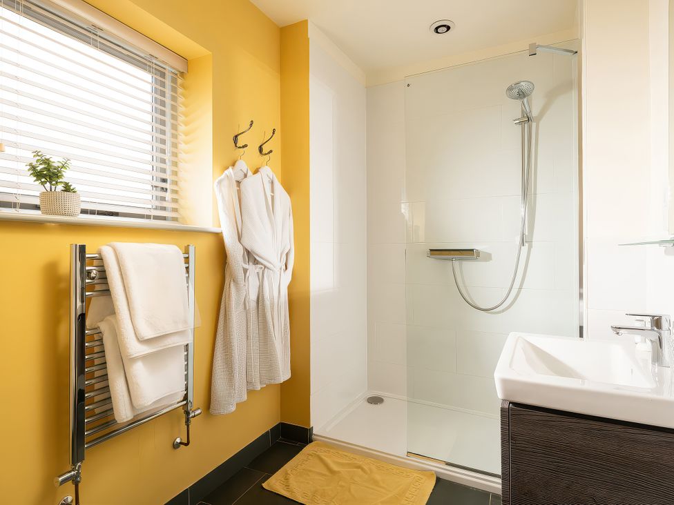 A bathroom with a shower and sink at Flyfishers Cottage in Llandrillo