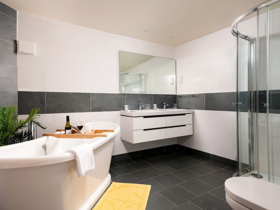 A bathroom with a bathtub and sink at Flyfishers Cottage in Llandrillo